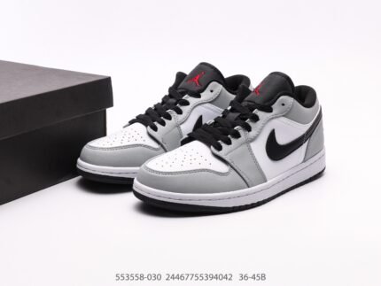 A pair of grey and white sneakers with black details and logo, next to a black box.