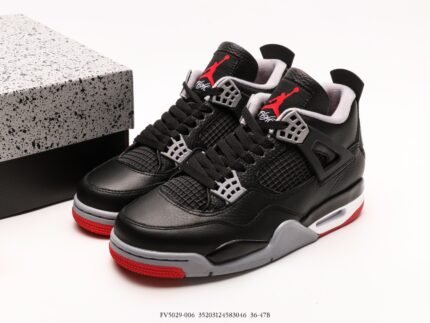 Black sneakers with red accents, white laces, black shoebox beside