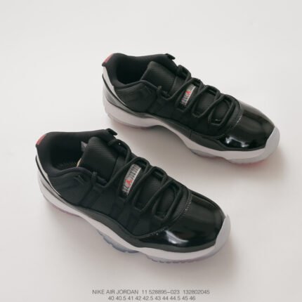 A pair of black sports shoes with red details and white soles.