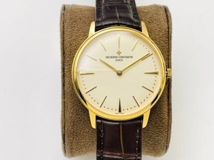 A gold watch with a white dial and a brown leather strap.
