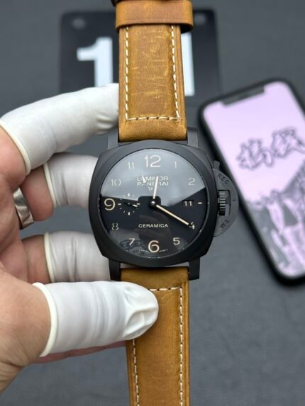 A black wristwatch with a tan leather strap and a unique dial design.