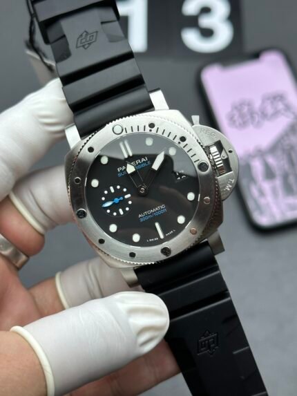 A black wristwatch with a black dial and silver accents on a black strap.