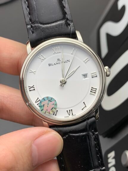 A classic silver watch with a white dial, black leather strap, and Roman numeral hour markers.