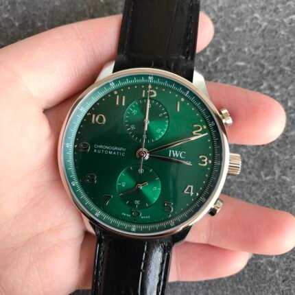 A wristwatch with a green dial and black strap held in a hand.