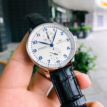 A wristwatch with a white dial and black leather strap.