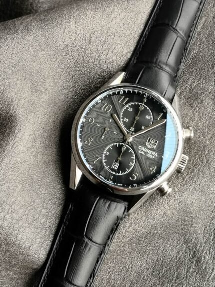 A black wristwatch with a chronograph dial and black leather strap.