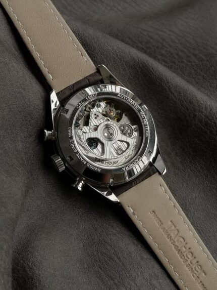 A black wristwatch with a skeleton dial on a black leather strap.