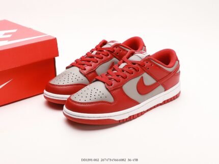 A pair of red and gray Nike Dunk Low sneakers next to a red Nike shoebox.