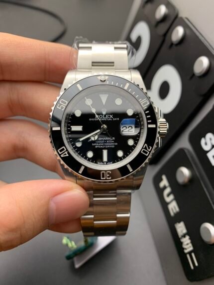 A silver wristwatch with a black dial and silver bracelet on a person's wrist.