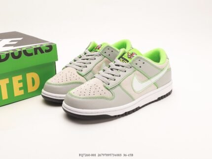 A pair of gray and green Nike Dunk Low sneakers next to a green shoebox with "DUNK" written on it.