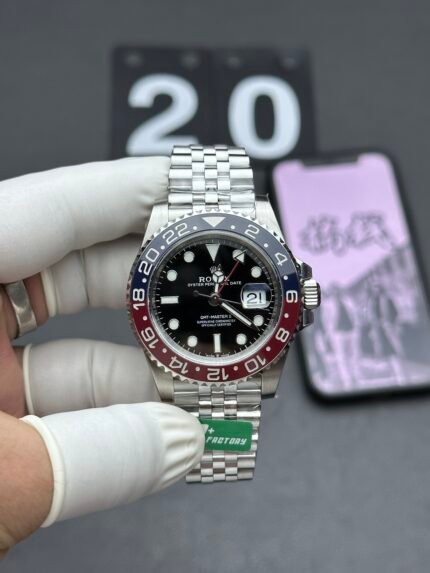 A silver wristwatch with a black dial and red accents on a silver bracelet.