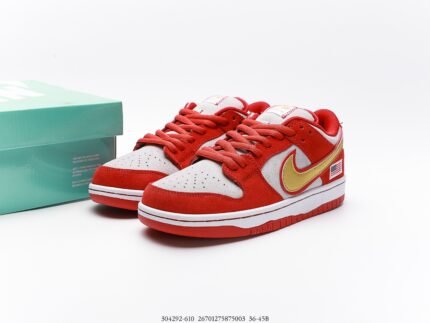 A pair of red and white Nike Dunk Low sneakers with a green shoebox.