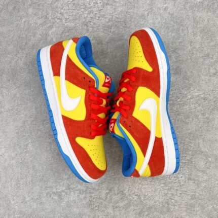Red and yellow Nike SB Dunk Low Pro sneakers with blue lining on a gray background.