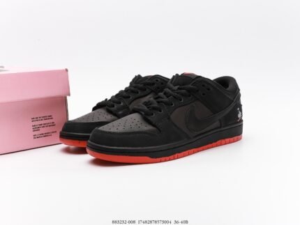 Black Nike Dunk Low sneakers with red soles and a pink shoebox.