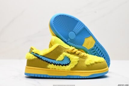 Yellow Nike Dunk Low sneakers with a cartoon character on the tongue and a colorful shoebox.