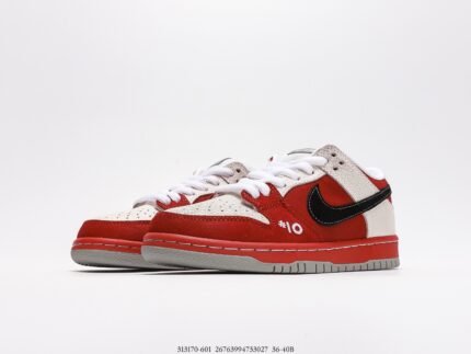 This is a pair of red and white Nike Dunk Low sneakers, featuring a high-quality leather upper and the classic black Swoosh logo, making them look stylish and energetic. The design of the shoes is simple and elegant, with white laces complementing the red and white upper. The brand logo on the tongue highlights their authentic identity. The red rubber outsole provides good wear resistance and traction, making them suitable for daily wear and sports. The blue shoebox next to the shoes has the Nike logo and product information printed on it, further highlighting the brand's premium image.