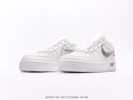 A pair of white sports shoes with gray and orange accents