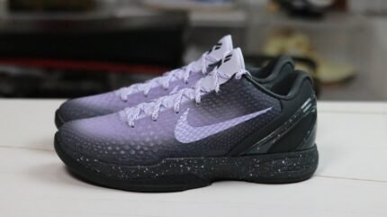 A pair of black sports shoes with white laces and breathable mesh