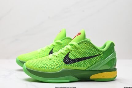 A pair of green sports shoes with black detail accents and a yellow sole