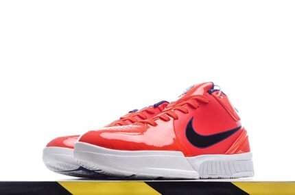 Red sports shoe with a black logo, white sole, and a yellow and black striped background