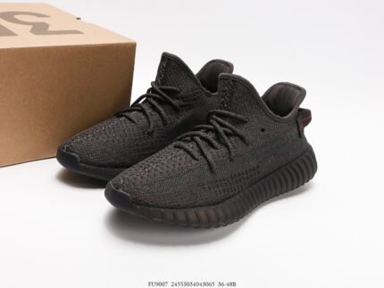 Black sports shoes with black details, next to a shoebox.