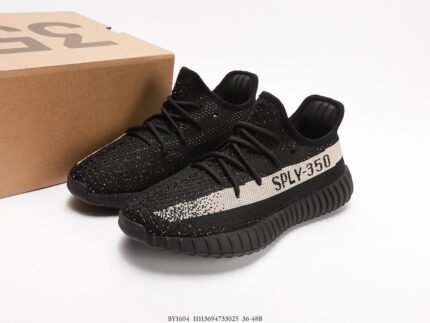 A pair of black sports shoes with white accents, next to a shoebox.