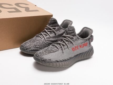 The image shows a pair of gray sneakers with a Primeknit upper that offers excellent breathability and a snug fit. The side of the shoe is adorned with the red text "SPLY-350," adding a vibrant touch to the design. The outsole is made of dark rubber with a unique pattern that aims to provide good cushioning and traction. The design of these shoes focuses on both comfort and style, making them suitable for a variety of occasions.