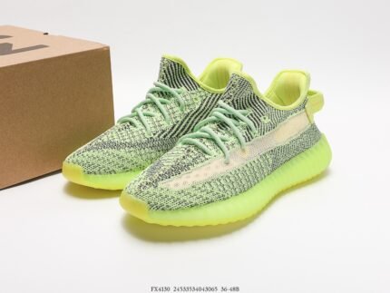 Green sports shoes with light-colored details, next to a shoebox.