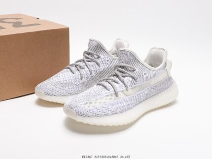 White sports shoes with light-colored details, next to a shoebox.