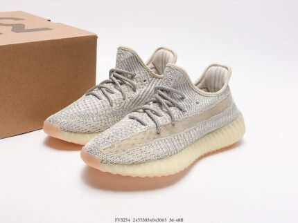 Grey sports shoes with light-colored details, next to a shoebox.