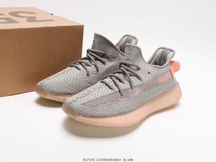 Gray sports shoes with red accents next to a shoebox.