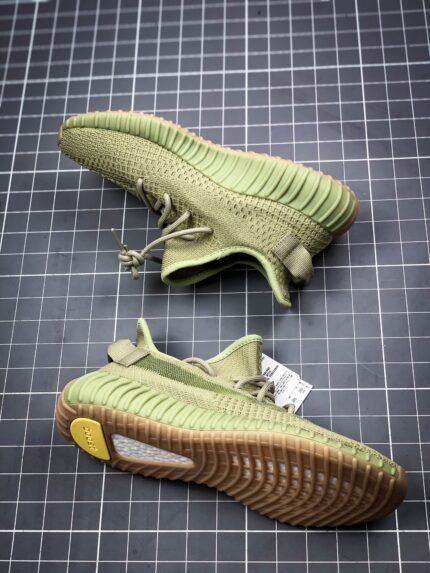 Yellow sports shoes with black accents next to a shoebox.