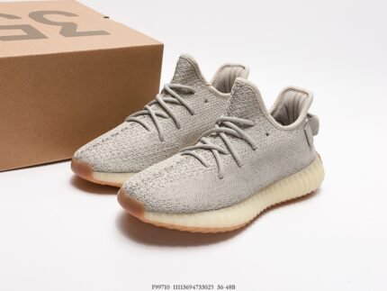 Gray sports shoes with orange accents next to a shoebox.