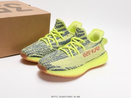 A pair of fluorescent green sports shoes with black accents, next to a shoebox.