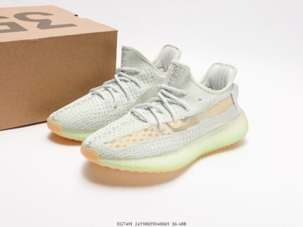 Beige sneakers next to a cardboard box.