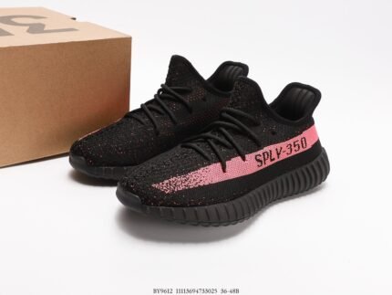 The image shows a pair of black sneakers with a Primeknit upper that features the pink "SPLY-350" text on the side, adding a vibrant touch to the design. The laces are black, matching the upper for a cohesive look, and the overall design is simple yet stylish. The outsole is made of black rubber with a distinctive pattern that aims to offer good cushioning and traction. These shoes are suitable for both sportswear and casual daily wear, making them a versatile choice with their modern design and comfortable fit.