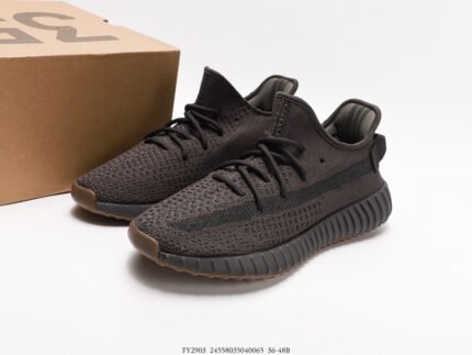 The image showcases a pair of dark gray sneakers with a Primeknit upper, known for its excellent breathability and fit. The laces match the color of the upper, maintaining a uniform design. The outsole is made of dark rubber with a distinctive pattern that aims to offer good cushioning and traction. The style of these shoes is simple and modern, suitable for various casual occasions and sports activities.