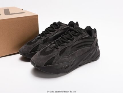 All-black sneakers next to a branded shoebox