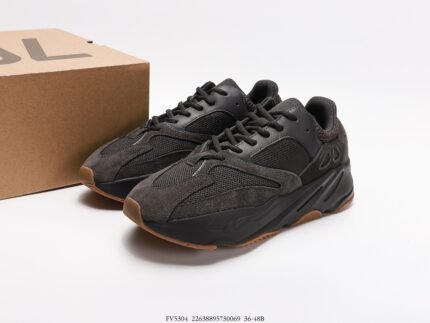 Dark grey sneakers with brown soles next to a branded shoebox