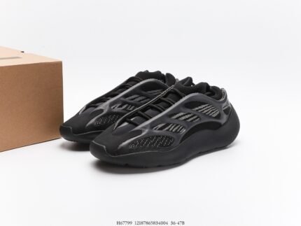 All-black sneakers next to a branded shoebox