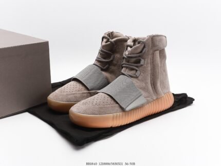 Grey high-top sneakers with orange soles next to a branded shoebox