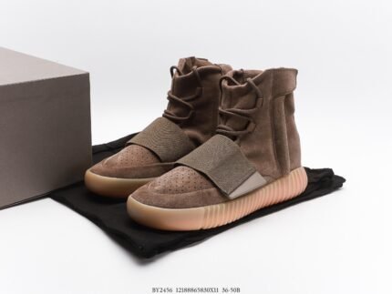 Brown high-top sneakers with orange soles next to a branded shoebox