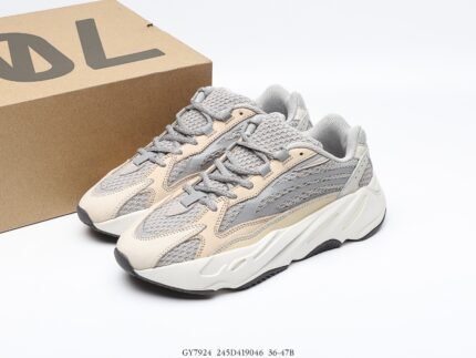 Grey and beige sneakers next to a branded shoebox