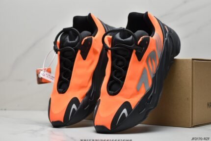 Orange and black sneakers next to a branded shoebox