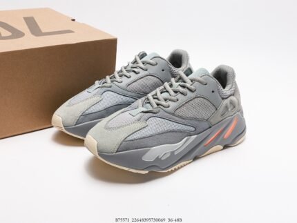 Grey sneakers with orange accents next to a branded shoebox