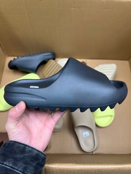 Black slide with serrated sole, displayed in hand