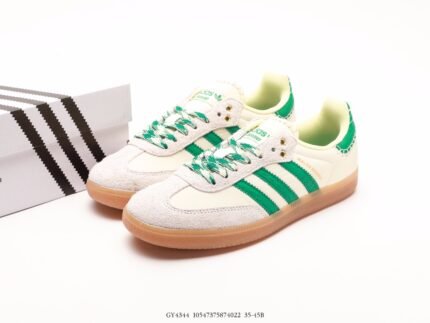 White sneakers with green stripes and details next to a branded shoebox