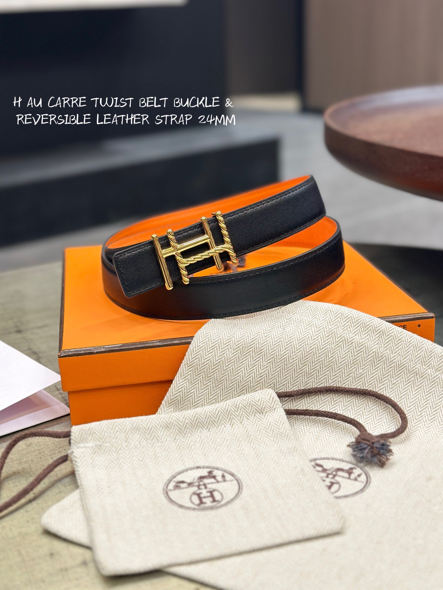 Reversible Leather Belt This is a reversible leather belt with a gold metal buckle, displayed on the brand's elegant packaging.