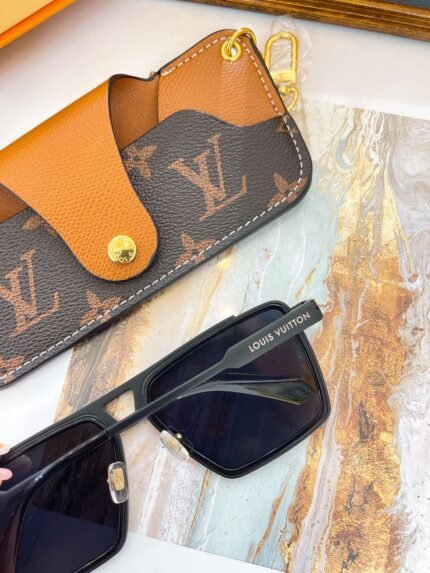 A pair of black Louis Vuitton sunglasses and a brown Louis Vuitton wallet on a marble surface.