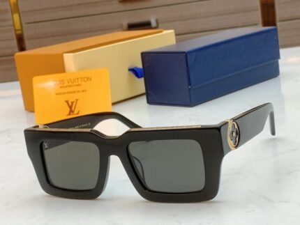 A pair of black square sunglasses with yellow and blue boxes.